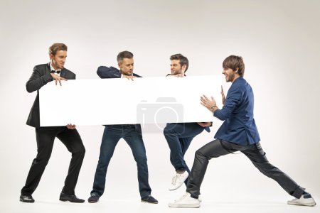 Four guys pushing the billboard