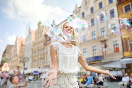 Cheerful girl looking through the huge bubble