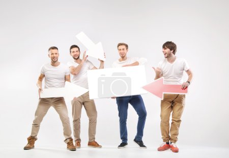 Group of joyful guys holding symbols