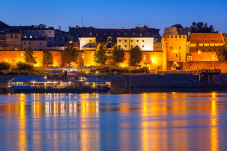 Old town of Torun at night reflected in Vistula river