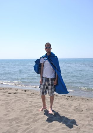 Funny superhero standing on beach