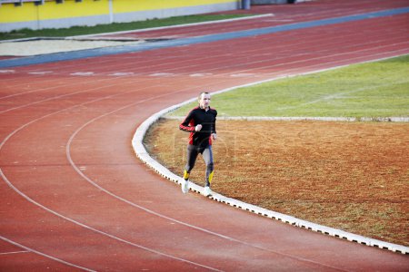 Adult man running on athletics track