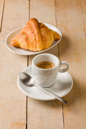 Coffee and croissants on wooden table