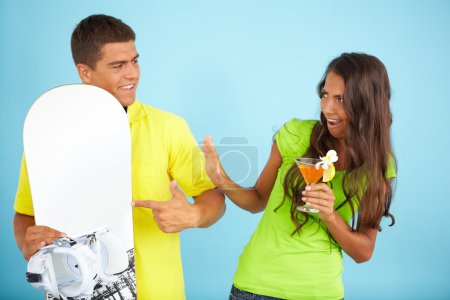 Girl with cocktail and man holding skateboard
