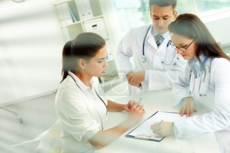 Practitioners prescribing medicine to patient