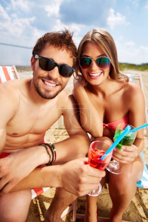 Lovers with drinks having beach party