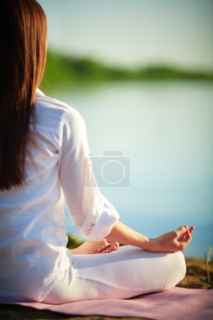 Woman relaxing in pose of lotu