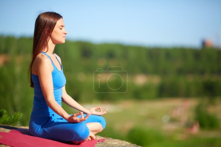 Woman relaxing in pose of lotus