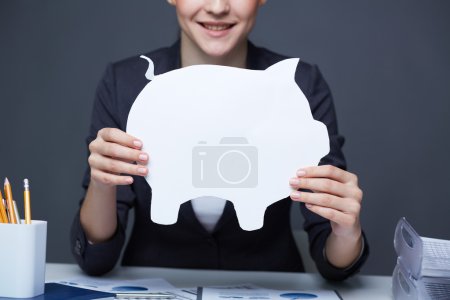 Businesswoman holding paper piggy