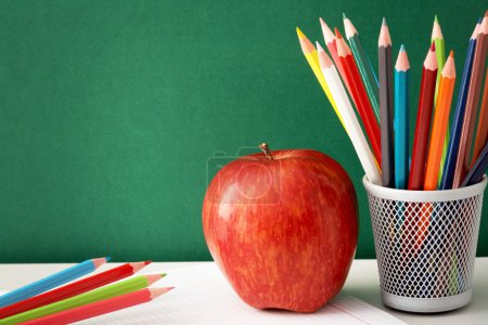 Colorful pencils and apple