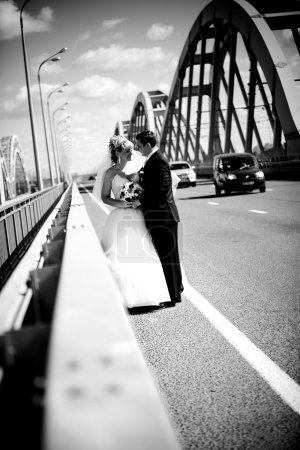 portrait of newly married couple hugging on road
