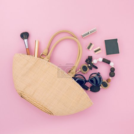 Ladies handmade bag with different accessories on pink background
