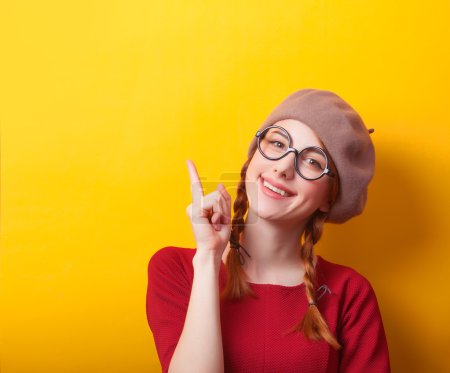 Redhead girl with pigtails on yellow background.