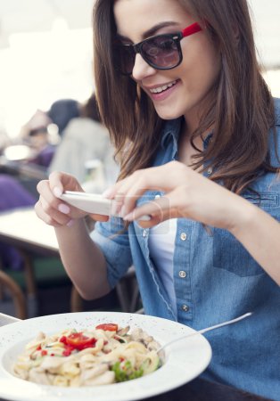 Woman taking a picture of italian meal