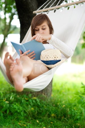 Woman reading a book on hammock