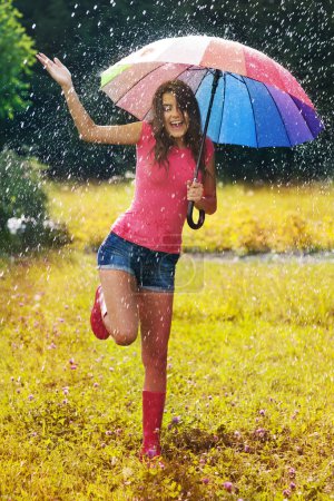Young and beautiful woman have fun in rain