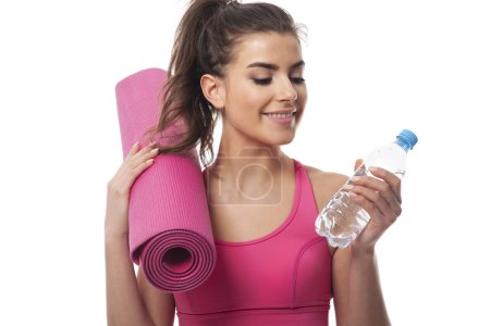 Woman with water and exercise mat