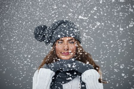 Beautiful young woman enjoys first snow