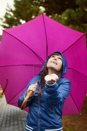 Young woman under pink umbrella