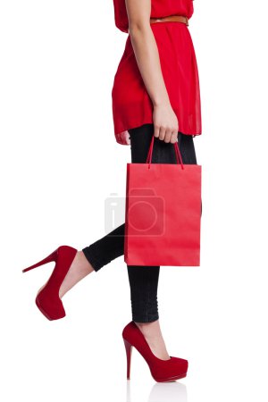 Low section of a woman with her red shopping bag