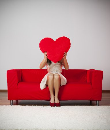 Woman holding heart shape pillow