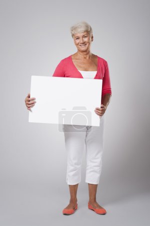 Senior woman holding blank whiteboard
