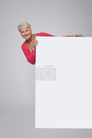 Senior woman with white billboard