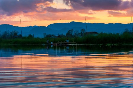 Fishermen and their reflection in the water on the Inle Lake, Myanmar