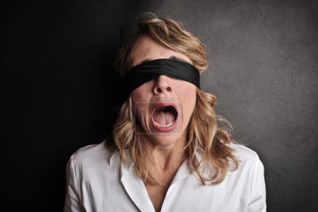 Scared woman with a black scarf on her eyes