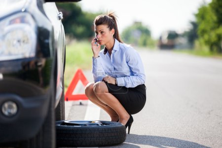 Conceptual photo of woman with a flat tire