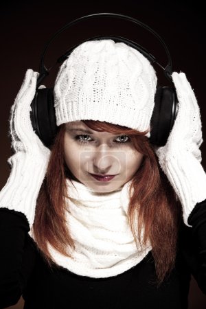 Red hair woman with winter outfit listening to music