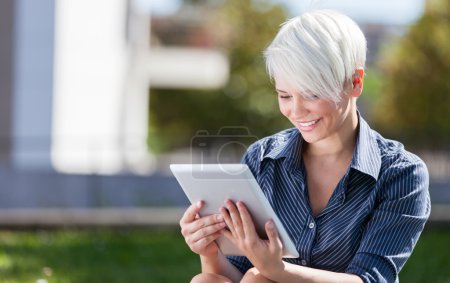Businesswoman outside in a park with tablet pc