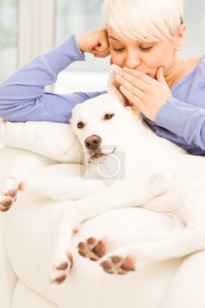 Blonde woman is playing with her dog