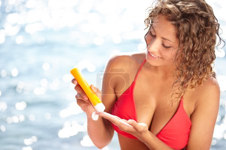 Woman applying sun block solar cream for UV protection
