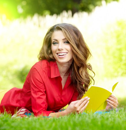 beautiful girl with book in the spring park