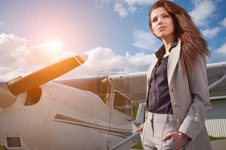 Businesswoman in front of airplane