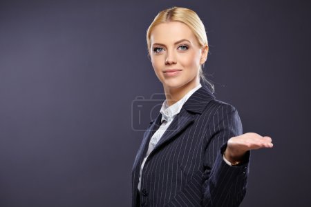 businesswoman presenting something on grey background