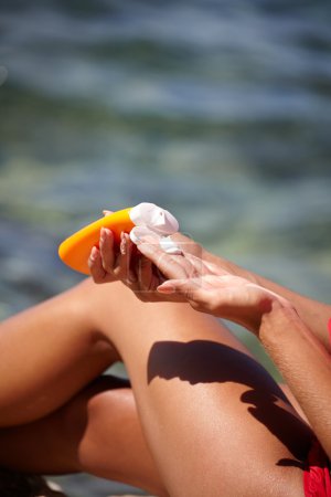 woman applying sun protection lotion 