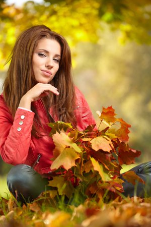 Young woman with autumn leaves in hand
