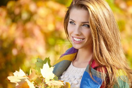 Young woman with autumn leaves in hand