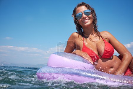 Woman relaxing on inflatable mattress.