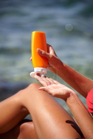 woman applying sun protection lotion 