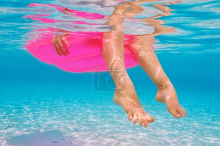 Woman relaxing on inflatable mattress, view from underwater