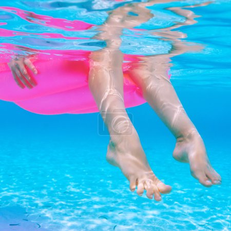 Woman relaxing on inflatable mattress, view from underwater