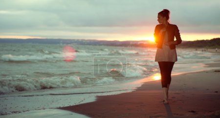 Young woman and the sunset in the background