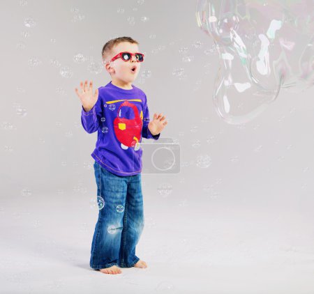 Little man playing with soap bubbles