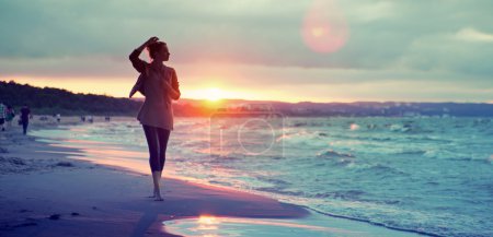 Alluring woman walking along the seaside