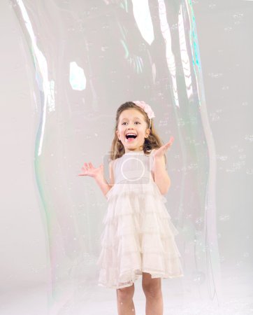 Cute child in the large soap bubble