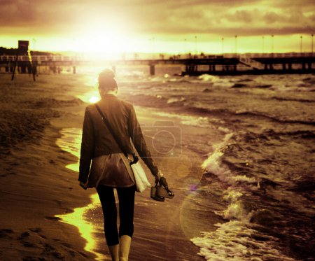 Art picture of young woman walking by the seaside