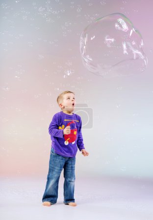 Cute little boy enjoying soap bubbles